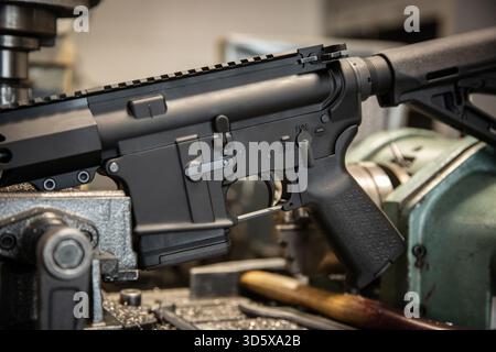Schwarzer AR-15-Gewehrempfänger in Nahaufnahme an industriellen Metallmaschinen in Werkstattumgebung. Stockfoto