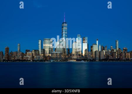 Ein atemberaubender nächtlicher Blick auf die Skyline von Downtown Manhattan, von Jersey City aus über den Hudson River, mit den Türmen des Finanzviertels Stockfoto