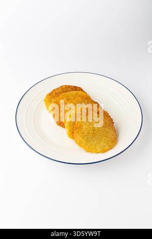 Ukrainisches Deruny, knusprige Kartoffelpfannkuchen auf einem Teller, isoliert auf weiß Stockfoto