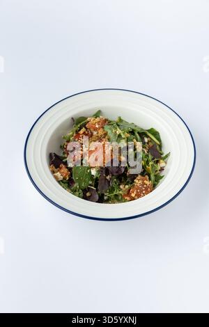 Gemischter grüner Salat mit gebratenem Kürbis, Walnüssen und körnigem Senfdressing, Studio Stockfoto