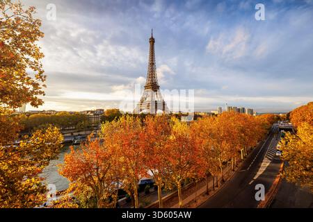 Panoramablick auf die Skyline von Paris, Frankreich, entlang des Ufers der seine mit Eiffelturm, goldenen Bäumen und Straßenverkehr Stockfoto