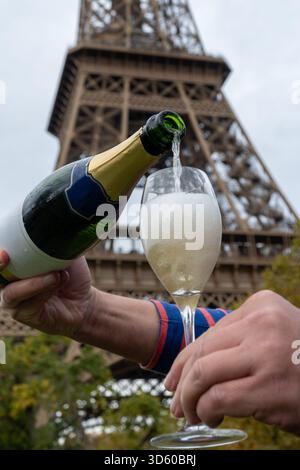 Ausgießen und Trinken von französischem Sekt aus Tulpenglas mit Blick auf die Straßen, Gebäude und Türme von Paris, Hochzeitsveranstaltung in Paris Stockfoto