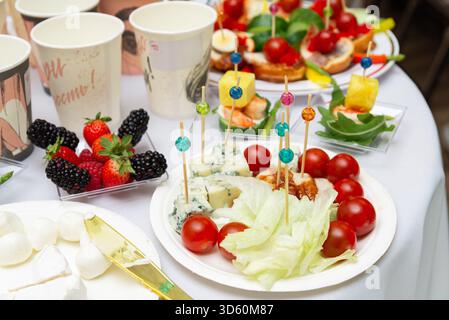 Moskau, Russland - 09. Oktober 2025 - Ein lebhaftes Angebot an bunten Snacks auf einem Tisch mit frischem Obst, Käse und Gemüse. Ein entzückendes s Stockfoto