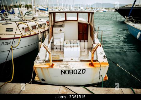 Das kleine Fischerboot NOBOZO legte an einem luftigen Tag im Jachthafen von Antibes an, umgeben von Segelbooten. Stockfoto