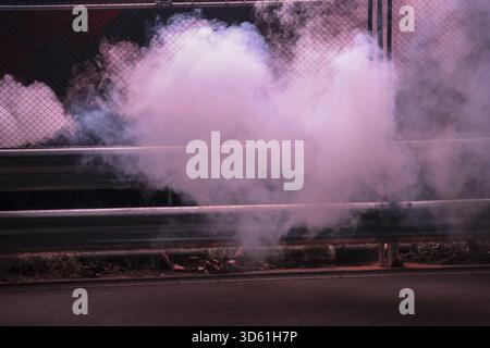 Geheimnisvoller rosafarbener Rauch und Dämpfe von Flare erzeugen dramatische, atmosphärische Effekte. Wolke aus Gas steigt in der Luft vor dunklem Hintergrund auf, gefährlich und abstr Stockfoto