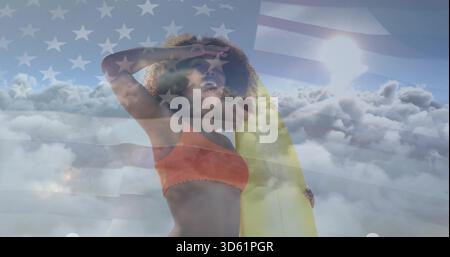 Mit gelbem Surfbrett, eine Frau in orange oben, die Augen am Himmel mit US-Flagge schattiert Stockfoto
