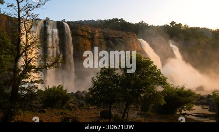 Die Athirappilly Falls leuchten bei der Golden Hour in Kerala, Indien. Diese malerische Landschaft fängt einen Moment der ruhigen Schönheit und des mächtigen Naturdramas ein. Stockfoto