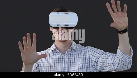 Lächelnder Mann mit kariertem Hemd im Studio, der mit weißem Headset interagiert, dunkles Armband Stockfoto
