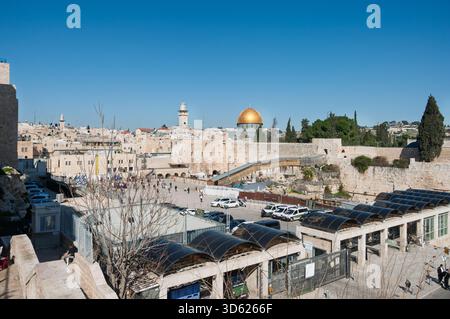 Blick auf eine Stadt mit einer großen Kuppel auf einem Gebäude. Die Kuppel ist Gold und der Himmel blau. Es gibt viele Leute, die herumlaufen und Autos parken Stockfoto