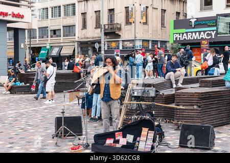 Athen, Griechenland - 15. Mai 2024: Straßenmusiker tritt für eine vielfältige Touristenmenge auf Stockfoto