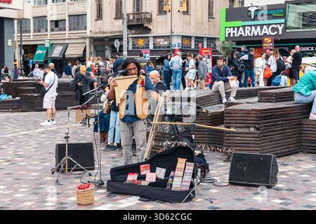 Athen, Griechenland - 15. Mai 2024: Straßenmusiker tritt für eine vielfältige Touristenmenge auf Stockfoto