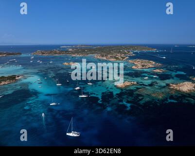 Blick aus der Vogelperspektive auf türkisfarbenes Wasser mit Felsvorsprüngen und Segelbooten in der Nähe des Maddalena-Archipels, Sardinien, Italien. Stockfoto