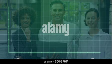 Posieren eines dreiköpfigen Teams in Geschäftskleidung mit Laptop und Anzeige eines grünen Rasterdiagramms im Büro Stockfoto