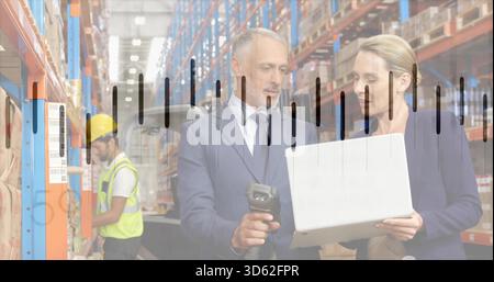 Überprüfung des Anzugs oder Blazers von Lagermanagern mit Laptop-Scanner im Lager, Hi-Vest Yellow-Hardha Stockfoto