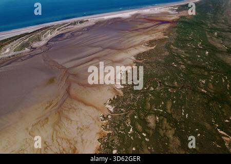Aus der Vogelperspektive auf die Findhorn Bay Area, wo die schlammigen Strukturen der Mündung auf das Grün des Landes mit dem dunkelblauen Meer im Hintergrund treffen, Findhorn, Stockfoto