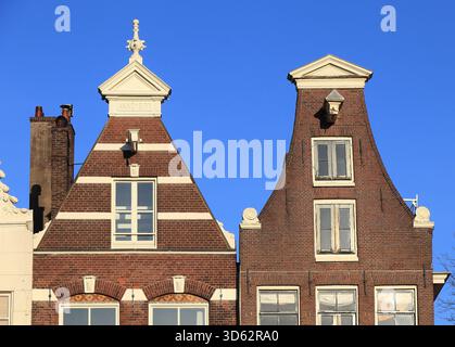 Zwei Fassaden des Brown and White Canal House schließen sich dem Blue Sky in Amsterdam, Niederlande, November 2025. Stockfoto