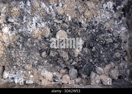 Verbrannte Kohlen aus Baumstämmen mit viel Staub und Dämpfen, Staub und verbrannte Kohlen nach dem Kochen von Fleisch auf dem Grill, Nahaufnahme Stockfoto