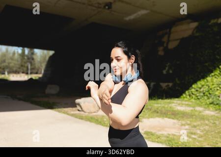 Eine junge Frau führt Dehnungsübungen in Armen und Schultern während eines Workouts in Saragossa, Spanien, durch Stockfoto