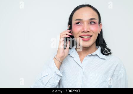 Studio-Porträt eines jungen thailändischen Transgender mit Make-up und langen Haaren. Das Konzept des Geschlechterausdrucks, des LGBTQ-Stolzes und der Inklusivität zeigt eine Stockfoto