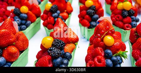 Frische Sommerbeeren in kleinen Marktkörben. Stockfoto