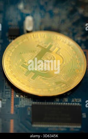 Bitcoin-Münze auf einem Computermotherboard, das digitale Währungstechnologie repräsentiert Stockfoto