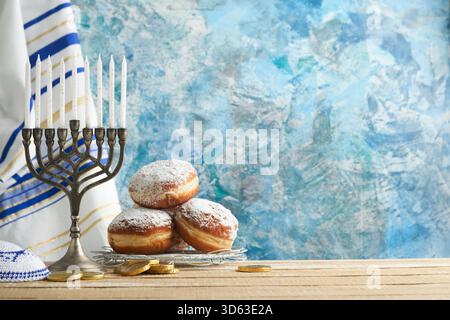 Happy Hanukkah. Hanukkah alte Menorah vor dem Hintergrund der israelischen Flagge mit Sonnenlicht oder Bokeh auf weißem hölzernem Hintergrund. Religionsbild des jüdischen Feiertags Hanukkah-Hintergrunds. Stockfoto