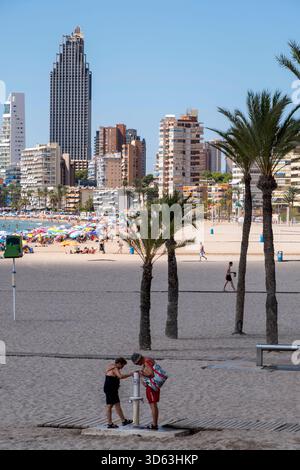 Touristen am Strand und Wolkenkratzer in Benidorm, Spanien Stockfoto