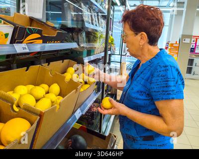 Woronesch, Russland – 13. September 2024: Eine ältere Frau wählt Zitronen in einem Laden Stockfoto