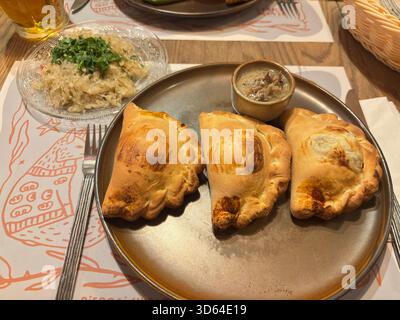 Gebackene Pierogi auf Teller im traditionellen Danziger Restaurant, Polen, mit Knödeln mit Käse- und Kartoffelfüllungen. Stockfoto