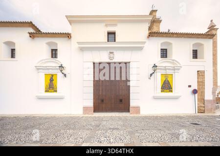 Antequera, Spanien - 7. September 2024: Großer Eingang zu einem historischen weißen Gebäude mit einer großen Holztür und dekorativen Elementen. Stockfoto