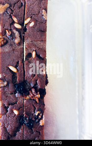Castagnaccio ist ein rustikales Dessert aus der Toskana, hergestellt aus Kastanienmehl, Wasser, Olivenöl, angereichert mit Pinienkernen, Rosinen, Walnüssen und Rosmarin. Stockfoto