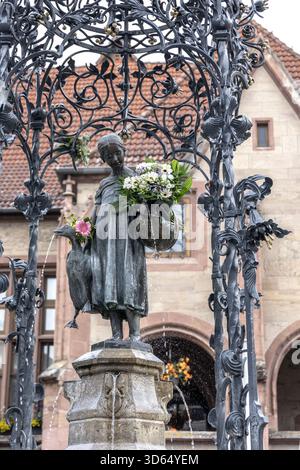 Die mit frischen Blumen geschmückte Gänseliesel-Brunnenstatue vor dem historischen Rathaus in Göttingen Stockfoto