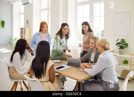 Ein Team aus verschiedenen Frauen diskutiert die Strategie im Büro an einem gemeinsamen Tisch Stockfoto