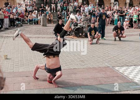Breakdancer von Kraków B-Boys Familia führt eine akrobatische Kopfständer-Variation während einer Straßenshow am Hauptmarkt durch. Stockfoto