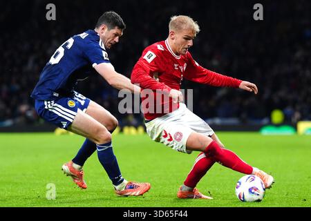 Der dänische Gustav Isaksen (rechts) und der schottische Scott McKenna kämpfen um den Ball während des Qualifikationsspiels zur FIFA-Weltmeisterschaft im Hampden Park, Glasgow. Bilddatum: Dienstag, 18. November 2025. Stockfoto