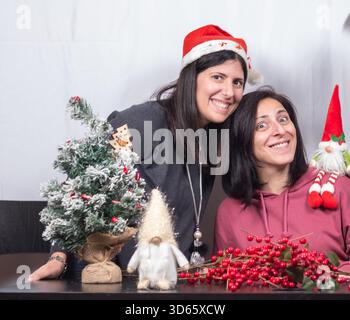 Zwei Frauen, die bereit sind, Weihnachten zu feiern. Die beiden Freunde sind etwa vierzig Jahre alt und sizilianischer Herkunft Stockfoto