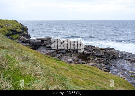 Entdecken Sie die atemberaubende Küstenlandschaft von Donegal, Irland, mit dramatischen Klippen, Felsformationen und stürzenden Wellen, erwecken ein Gefühl von Adven Stockfoto