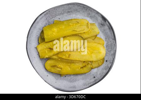Dünne eingelegte Gurkenscheiben mit Dill- und Senfsamen auf einer grauen Keramikplatte über weißem Hintergrund in der Draufsicht Stockfoto
