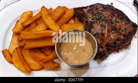 Steak mit dicken Pommes frites, serviert mit Soße aus schwarzem Pfeffer Stockfoto
