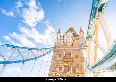 Die Tower Bridge erhebt sich majestätisch vor einem klaren blauen Himmel in London und zeigt komplexe architektonische Details und historische Bedeutung, die Besucher einladen, ihr einzigartiges Design zu bewundern. Stockfoto