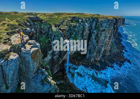 Mann und Frau Wandern mit Blick auf den Wasserfall des Mfihlelo River, Wild Coast Trail, Wild Coast, Eastern Cape, Südafrika Stockfoto