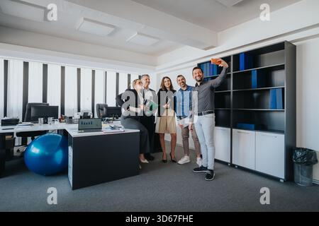 Team von Profis posiert in modernen Büroumgebungen für Selfie Stockfoto