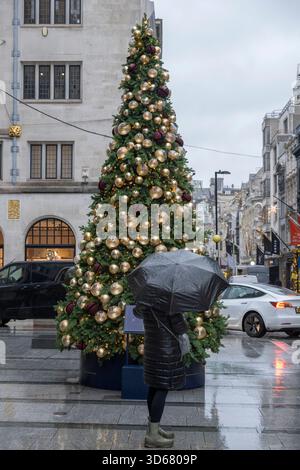 New Bond Street, London, Großbritannien. November 2025. Kälte und Schneeregen in Mayfair bei grauem Wetter mit farbenfrohen Geschäften, die zu Weihnachten 2025 dekoriert sind. Quelle: Malcolm Park/Alamy Live News Stockfoto