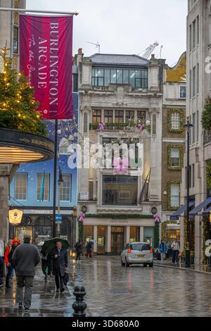 New Bond Street, London, Großbritannien. November 2025. Kälte und Schneeregen in Mayfair bei grauem Wetter mit farbenfrohen Geschäften, die zu Weihnachten 2025 dekoriert sind. Quelle: Malcolm Park/Alamy Live News Stockfoto