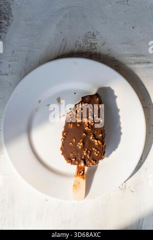 Eis mit Schokoladenüberzug und gehackten, gesalzenen Nüssen Stockfoto