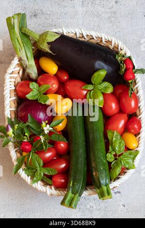 Korb mit Aubergine, Zucchini, Zwiebel und Tomaten Stockfoto