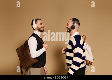 Zwei Brüder in stilvoller Kleidung und Kopfhörern teilen einen freudigen Moment in einer warmen Atmosphäre. Stockfoto
