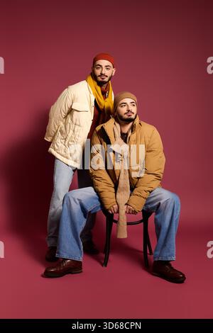 Zwei stilvolle Zwillingsbrüder stehen selbstbewusst und zeigen ihre starke Verbundenheit. Stockfoto