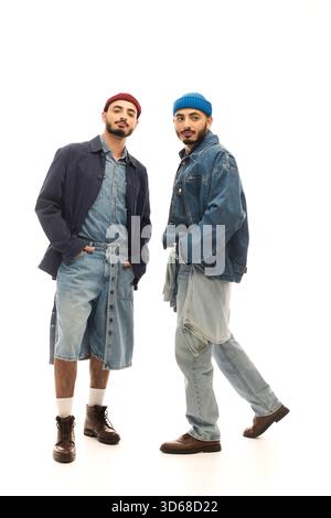 Zwei stilvoll gekleidete Brüder posieren zusammen und strahlen Selbstvertrauen und Charisma aus. Stockfoto