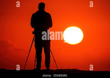 Isle Of Palms, Usa. November 2025. Ein Fotograf im Sonnenlicht fotografiert den Sonnenaufgang am Front Beach am 19. November 2025 in Isle of Palms, South Carolina. Quelle: Richard Ellis/Richard Ellis/Alamy Live News Stockfoto